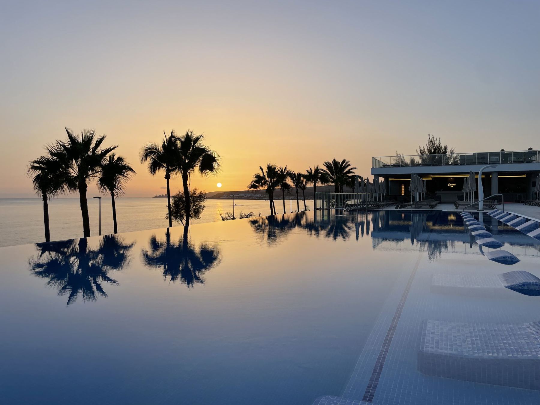 Piscina infinita de un hotel RIU al atardecer