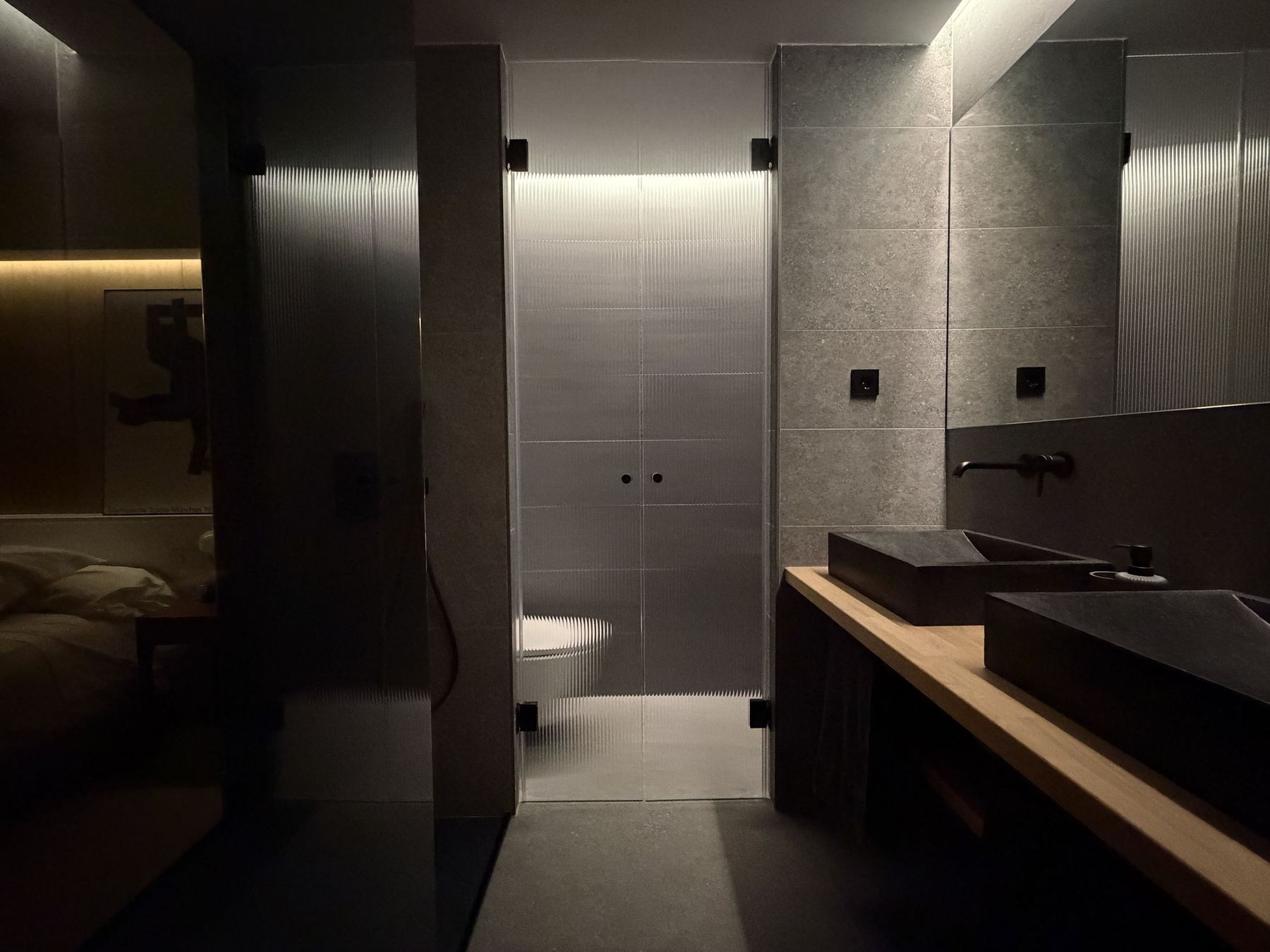 Baño con revestimiento de gran formato y griferías negras