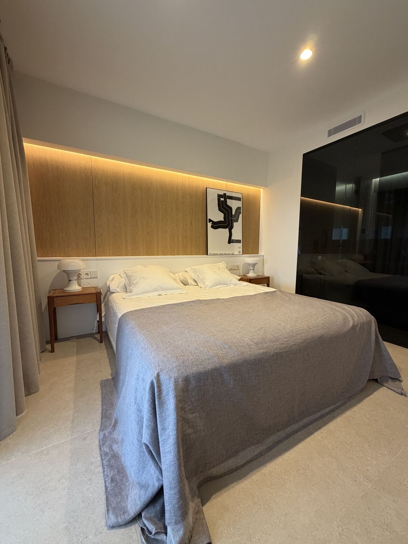 Dormitorio con cortinas de lino y cabecero de madera